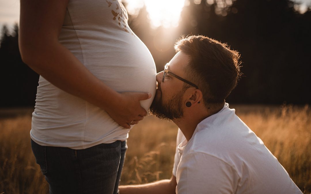 Kuss Babybauch Sonnenuntergang