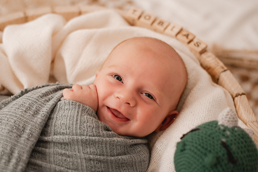 Baby lachend in Körbchen