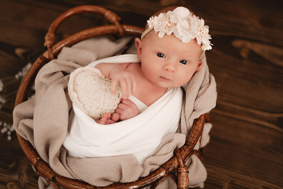 Baby eingewickelt in Körbchen